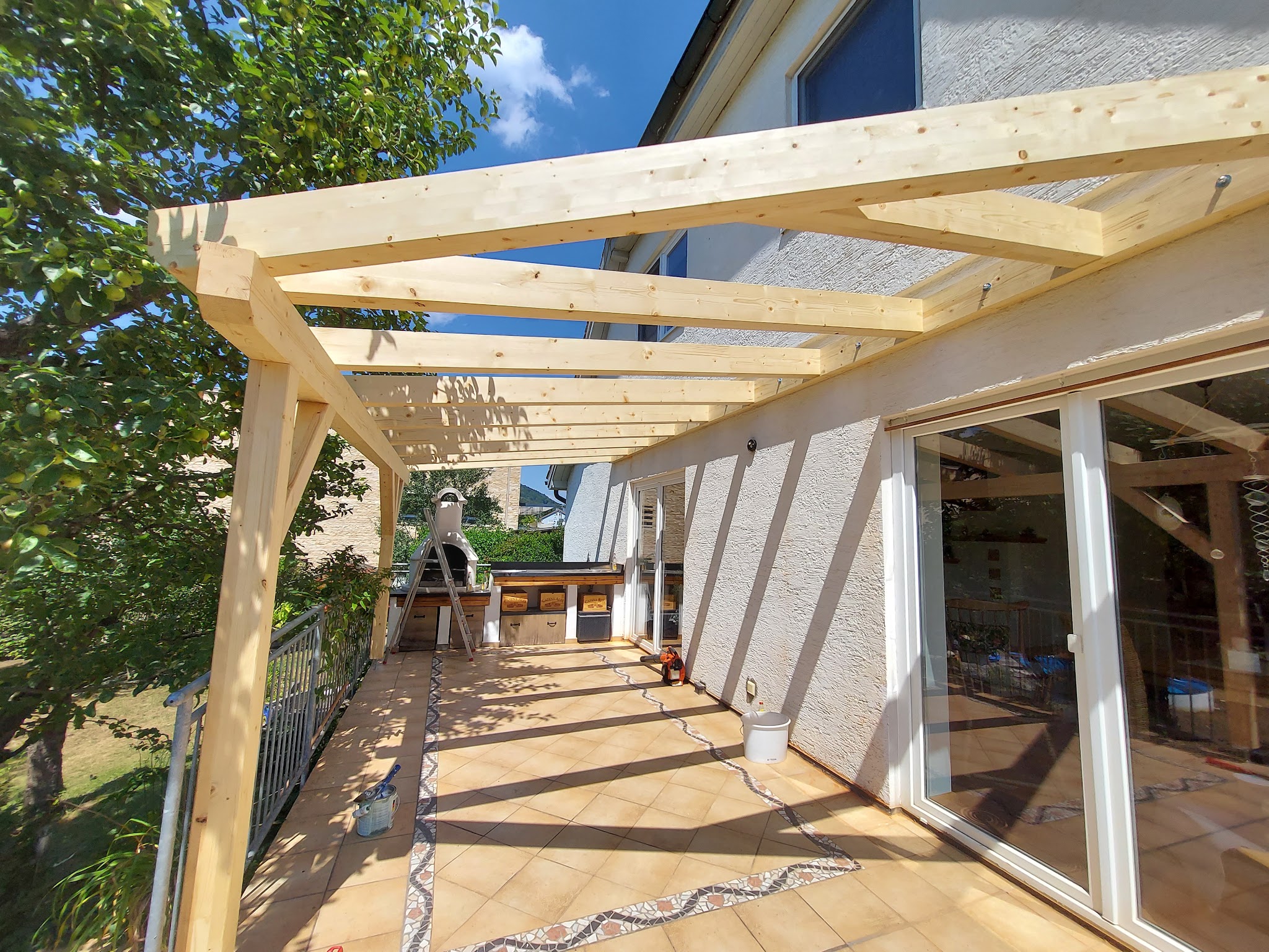 Terrassenüberdachung aus Holz über einer Sitzecke