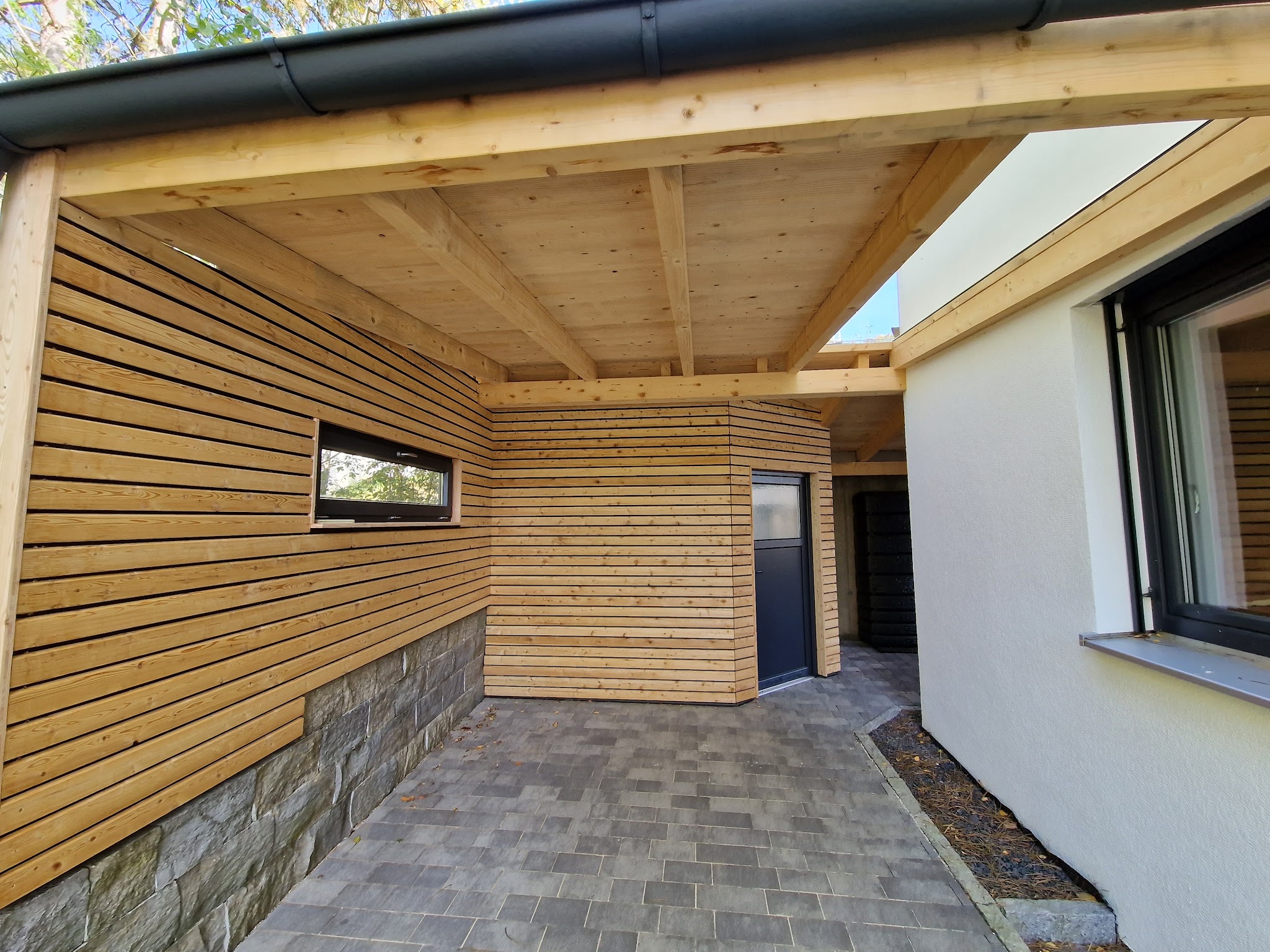Fertig verkleideter Carport mit Natursteinsockel