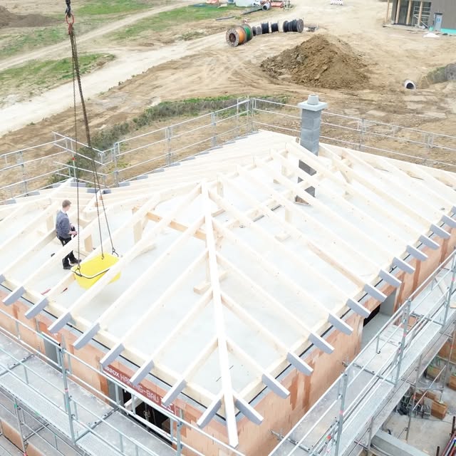 Drohnenaufnahme einer Dachstuhlmontage mit Kran